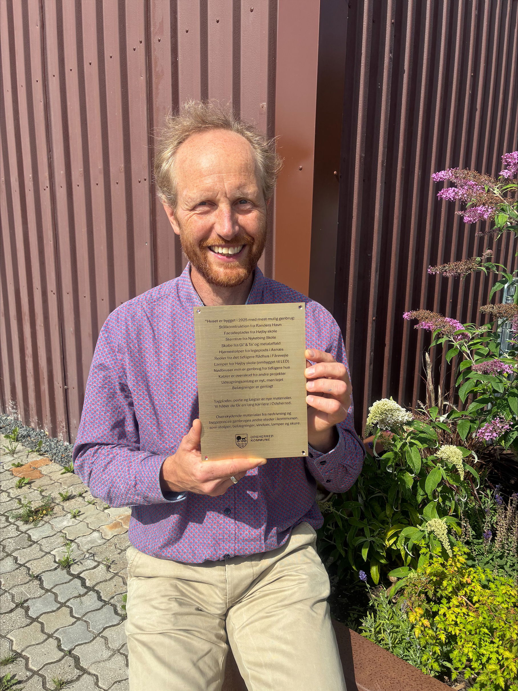 Mand står med en plakette